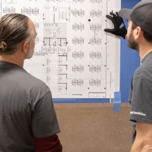 two men reviewing project plan on wall