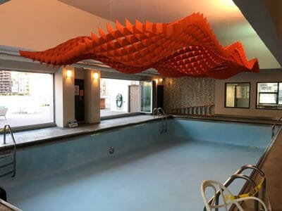 orange-acoustic-ceiling-design-above-empty-pool orange acoustic ceiling design suspended above empty swimming pool