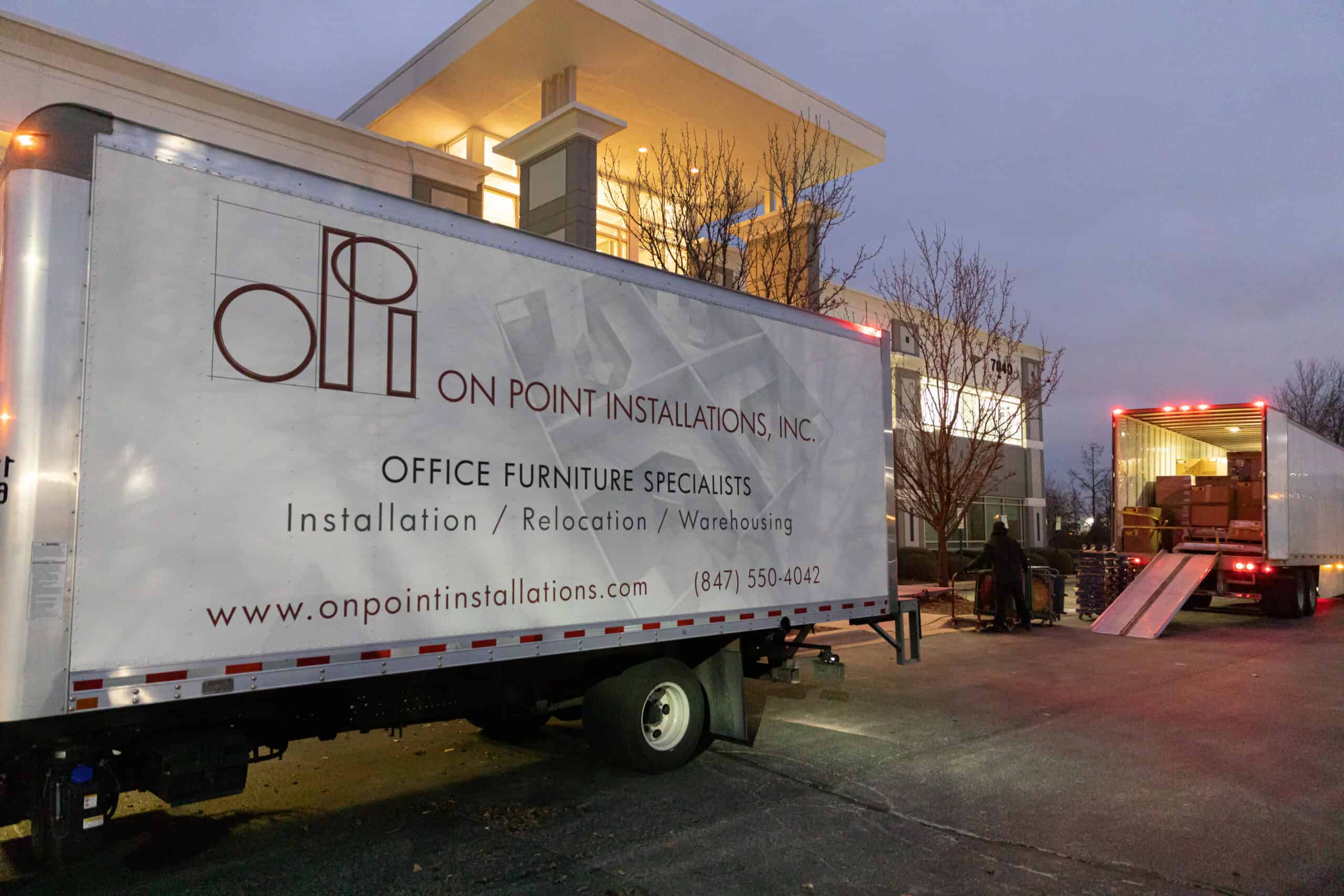 On Point Installations Unloading Trucks at Dusk